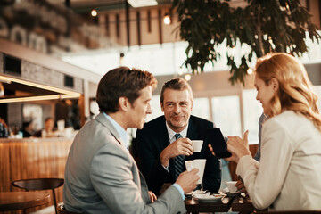 Wall Mural - Diverse group of business friends having coffee after work in a café decorated for Christmas and the new year holidays