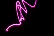 Luz en forma de viboreo color rosa de luz de neón, con  velocidad y movimiento vibratorio borroso,  presenta un diseño abstracto original con fondo negro