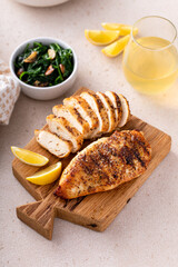 Wall Mural - Grilled chicken breast, whole and sliced on a cooking board