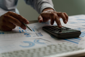 Wall Mural - man using a calculator accountant working on desk budget and loan Close up Accounting analysis, tax finance, bank income savings budget