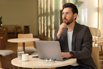 Canvas Print - Man with laptop at table in cafe