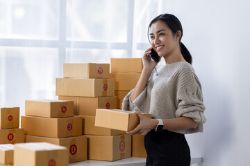 Starting small businesses SME owners asian female entrepreneurs call phone on receipt box and check online orders to prepare to pack the boxes, sell to customers, SME business ideas online.