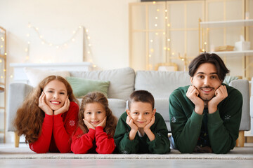 Poster - Happy family in warm sweaters lying on floor at home