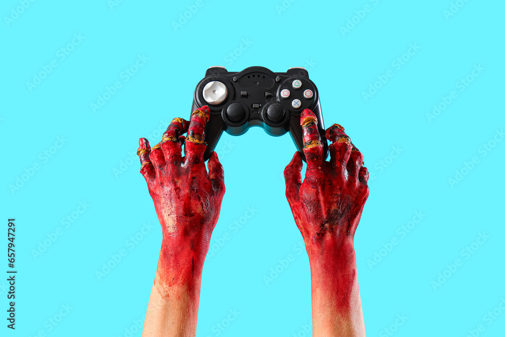 Bloodstained zombie hands with game pad on blue background. Halloween celebration