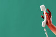 © Pixel-Shot - Bloodstained zombie hand with telephone on green background. Halloween celebration