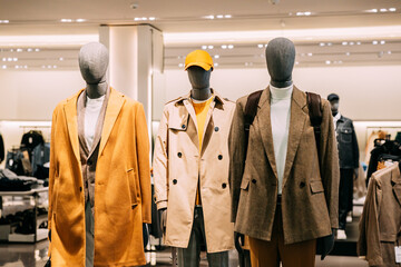 Wall Mural - Mannequins Dressed In Men male Casual Clothes And coat jackets Clothes In Store Of Shopping Center. Stack clothes In Store Of Shopping Center. shelf display in shop mall store. Store Of Shopping