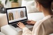 © Tony - Clous-up A person using a laptop to browse and shop for fashion online.Generative AI