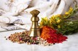a brass mortar and pestle surrounded by colorful spices on a white table