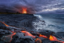Close-up Of Lava Flowing From A Rock Column And Pours Into A Volcanic Landscape. Lava Flow At Kalapana Beach After Sunset With An Explosive Eruption Of The Kilauea Volcano At Big Island Hawaii Islans