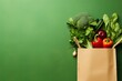 Shopping bag full of fresh organic vegetables on green background. Healthy food concept