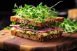 sandwich with microgreens and ham on rye bread