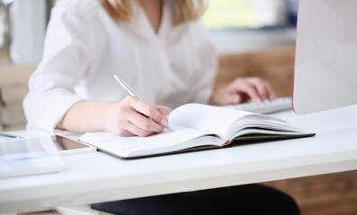 Wall Mural - Female hand holding silver pen ready to make note in opened notebook sheet. Businesswoman in suit at workspace make thoughts records at personal organizer white collar conference signature concept