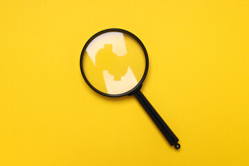 Wall Mural - A magnifying glass in a black frame on a yellow background