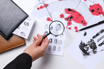 Wall Mural - Books, magnifying glass with fingerprints on a white background