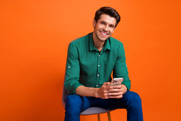Aufkleber - Photo of optimistic smile young businessman chatting messenger online app for communication sellers isolated on orange color background