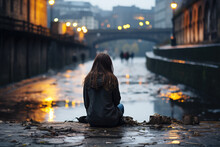 Young Woman  Sitting In Middle Of A Wet Street