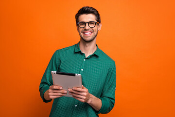Fototapete - Photo of cool positive guy wear green shirt communicating modern gadget isolated orange color background