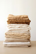 A stack of clean, comfortable linen towels arranged neatly on a beige table, creating a tidy and organic setting.
