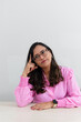 © Thales - A psychopedagogue wearing pink clothes, in her office, sitting, thinking. helps with school performance.