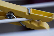 A Yellow Clothespin With A White Wire