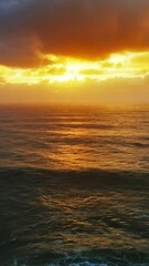 Wall Mural - Aerial view on big waves of Atlantic ocean and dramatic sunset sky. Vertical video