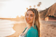 © Daniel - Portrait of one happy beautiful woman on the sand of the beach enjoying and having fun at the sunset of the day. Looking at the camera smiling..