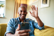 © Marko Geber - Middle aged African American having a video chat on the smartphone at home