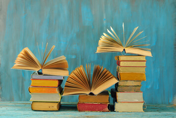 Wall Mural - Stack of books with 3 open books, international book fair, reading, learning, education or home office concept