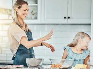 Canvas Print - Mother and daughter, baking and smile with flour in kitchen and love by bonding. Happy family, fresh ingredients and fun in learning, cake and dessert or play for breakfast, snacks and food at home