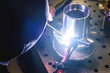 A welder makes a precision weld on a stainless-steel element. The element is used for professional kitchen equipment.