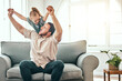 © Clement Coetzee/peopleimages.com - Father, girl kid and airplane on sofa, smile and playful for love, care and bonding in living room at family home. Dad, daughter and plane game, excited and relax together on lounge couch in house