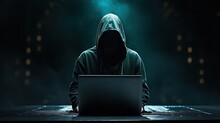 Guy Hacker Sits At A Table In Front Of A Laptop On A Dark Background. The Man Is Stealing Data. The Concept Of Cybercrime And Cybersecurity. Technology Illustration For Banner, Brochure, Presentation.