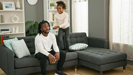 Sticker - African american father and daughter sitting on sofa stressed for disturb at home