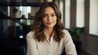 © Konrad - Successful Businesswoman in Office: Portrait of a Beautiful Happy Woman Looking at the Camera While Sitting at her Desk