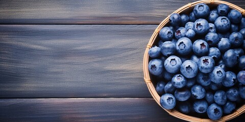 Wall Mural - Ripe blueberries in a wicker bowl on a blue rustic wooden table. Flat lay shot. Harvesting and healthy nutrition and vitamins concept background with copy space. : Generative AI