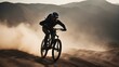 silhouette of a cyclist descending a hill on a mountain bike in dust and smoke