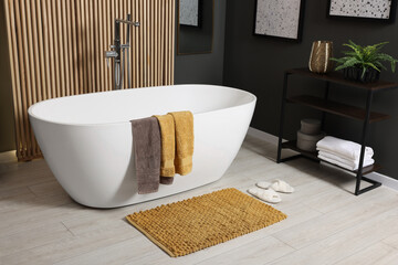 Wall Mural - Stylish bathroom interior with bath tub, houseplant and soft yellow mat