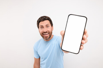 Poster - Handsome man showing smartphone in hand on white background