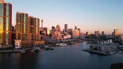 Wall Mural - Sydney, Australia: Aerial drone footage of the Darling Harbor newly redeveloped district in downtown Sydney at sunset in Australia largest city with a forward motion