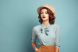 portrait of a beautiful fashion woman wearing vintage blue clothes and hat on bright blue colour background
