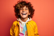 © sam - Colourful portrait of a young boy laughing and smiling wearing yellow jacket on bright orange background