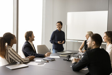 Poster - Happy creative multiethnic team of employees working on project together, discussing professional cooperation in meeting room with white board, collaborating on common tasks