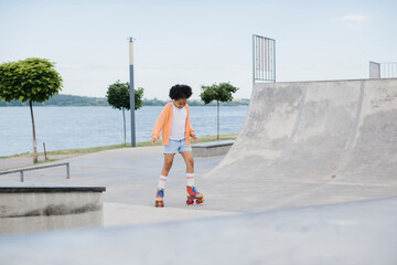 A teenage girl is rollerblading in a summer park. The concept of summer recreation outdoors.