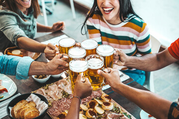 Group of people drinking beer at brewery pub restaurant - Happy friends enjoying happy hour sitting at bar table - Closeup image of brew glasses - Food and beverage lifestyle concept