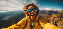 Portrait of a man with a backpack taking selfie photo on the top of mountain peak background.