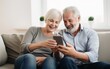 © COC STUDIO - Middle-aged couple sitting together and using smartphones.