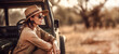 Woman in adventurer outfit on african safari. Sitting next to her off road car, blurred savanna background. Banner