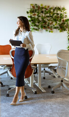 Young woman with digital tablet standing in the modern office