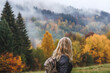 © encierro - Hiking in autumn forest. Woman during hike in mountain. Fog weather