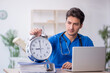 © Elnur - Young male doctor in time management concept